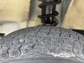 Close-up of a worn tire with a textured tread pattern mounted on a 2010 Daihatsu Hijet
