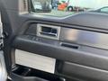 Interior view of a 2014 Ford F-150 door panel featuring controls for window and locks with a sleek design and textured surfaces