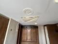 Interior view of a 2013 Outdoor Wind River camper featuring a round ceiling vent and a valance above wooden cabinets