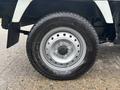 A close-up of a 2010 Suzuki Carry's wheel featuring a silver alloy rim and a black tire with visible tread and brand markings