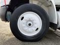 A close-up of a white wheel with a black tire featuring the Michelin logo and multiple lug nut holes on a 2013 International Durastar 4300 truck