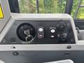 The control panel of a 2012 Caterpillar 980 featuring ignition keyhole switches and buttons for various functions including a 12V outlet