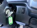 A close-up of the steering column of a 2015 Hino 358 showing the ignition key slot and two buttons for air control
