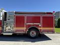 A 2004 American LaFrance Eagle fire truck featuring a red exterior with gold stripes and various equipment compartments on the side