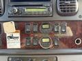 A dashboard of a 2012 Freightliner M2 106 featuring various control buttons gauges and a radio display