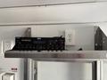 A Pyle audio mixer with various knobs and buttons displayed on a shelf inside a vehicle