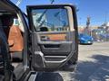 A 2015 RAM 1500 truck with a partially open driver's side door showcasing a brown leather interior and a detailed door handle