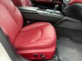 Red leather driver's seat of a 2016 Maserati Ghibli with detailed stitching and seat controls on the side