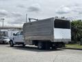 A 2020 Chevrolet Silverado truck with a large metallic box trailer attached at the rear