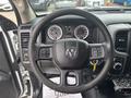 Steering wheel and dashboard controls of a 2016 RAM 1500 with gauges and gear shift displayed