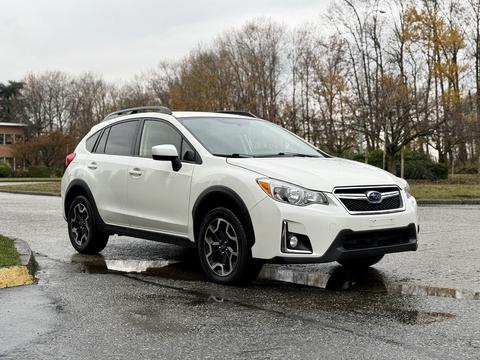 A 2016 Subaru Crosstrek in white with black and silver accents parked on a wet surface
