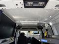 Interior view of a 2021 Ford Transit Connect showing a metal partition and shelves designed for cargo storage