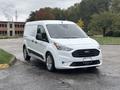 A white 2019 Ford Transit Connect van is parked at an angle showing its front and side view with a sleek design and distinctive grille