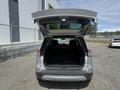 A 2014 Ford Escape with its rear hatch open revealing an empty cargo area and seats folded down