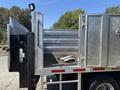 A 2019 Ford F-550 truck with an open metal flatbed and a hydraulic lift gate visible on the side