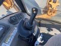 A close-up view of the control joystick and dashboard of a 2016 Case 580 Super N construction equipment with various levers and buttons