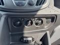 A control panel of a 2018 Ford Transit-350 featuring knobs for temperature and air conditioning settings along with a button indicating the door ajar status