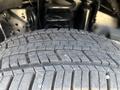 Close-up of a tire tread from a 2023 Ford F-350 SD showcasing deep grooves and a rugged design for traction