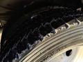 Close-up of a tire from a 2010 Ford F-550 showing detailed tread patterns and the rubber surface with some visible wear and tear