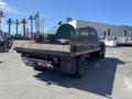 A 1996 GMC Top Kick with a flatbed design is parked, showcasing its large rear and distinctive body shape