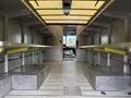 Interior of a 2012 Ford Econoline van featuring metal shelves on either side and a clear open space in the middle with an entrance visible at the front