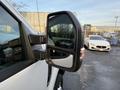 A 2018 Ford F-350 with a side mirror prominently displayed reflecting a nearby vehicle
