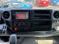 Dashboard of a 2020 Hino 155 featuring a touchscreen display audio system with climate control knobs and several blank switch panels for additional accessories