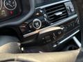 A close-up view of the control stalk in a 2013 BMW X3 featuring indicator and wiper settings