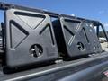 Two black fuel or water canisters mounted on a rack on a 2010 Toyota Tacoma