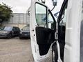 A white 2023 RAM Promaster 3500 with the driver's side door open revealing the interior design and seat layout