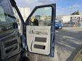 2011 Ford Econoline van with an open driver's side door showing the interior handle and speaker panel