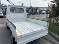 A 2010 Daihatsu Hijet light truck with an open cargo bed and a white exterior
