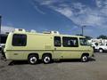 A vintage 1976 GMC Motorhome in a light green color with a streamlined design and multiple windows on the side