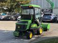 A 2021 John Deere 1575 lawn mower with a cab and a front-mounted mowing deck in green and yellow colors