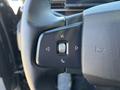 Close-up of the steering wheel controls of a 2023 Fisker Ocean featuring buttons for phone and navigation functions