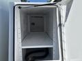 An empty compartment of a 2008 International DuraStar showing shelves and a hose inside the bottom section