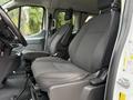 Interior view of a 2017 Ford Transit T150 XLT showing two gray fabric front seats with armrests and minimal console space between them
