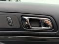 Close-up of a black door panel in a 2019 Ford Explorer featuring chrome accents and controls for windows and locks
