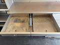 A metal workstation with two empty, dirty pull-out drawers and a flat surface on top