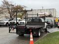 A 2008 Sterling Bullet truck with a flatbed and a black metal railing on the back parked in a lot. The truck is equipped with a trailer hitch and has visible wheel wells and tail lights