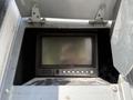 A panel with a black screen and buttons labeled Safety Visioninside an open compartment of a 2011 Freightliner M2 106