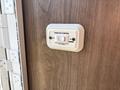 Slide-out control switch with an "IN" and "OUT" button mounted on a wooden surface