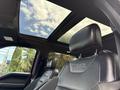 Interior view of a 2019 Ford F-150 Raptor showing black leather seats and a panoramic sunroof