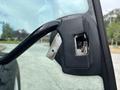 Close-up of the door handle mechanism on a 2009 New Holland T4020 tractor showing the latch and handle design