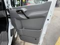The interior door panel of a 2012 Mercedes-Benz Sprinter featuring a grey handle storage compartment and controls