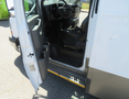 2020 Chevrolet Express van with an open side door revealing the driver's seat and interior features including controls and flooring details