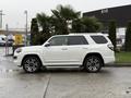 A white 2018 Toyota 4Runner is parked with a palm tree beside it showcasing its sleek design and alloy wheels