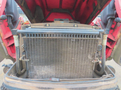 A 2013 Toro Grounds Master 5910 engine section showing the radiator and connecting hoses with visible wear and dust