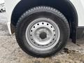 A close-up of the wheel of a 2010 Suzuki Carry featuring a silver steel rim and a Yokohama tire with visible tread pattern