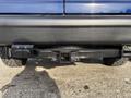 A 2013 Ford E-350 Super Duty rear view showing the hitch receiver and bumper with a black finish and visible tire tread above